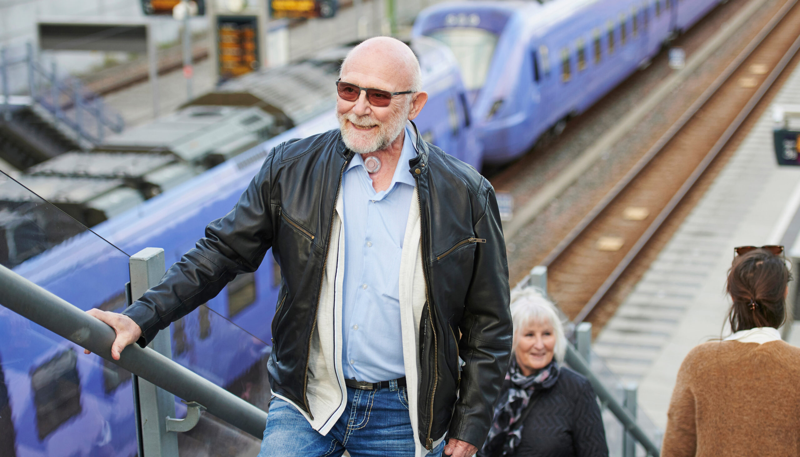 man living with laryngectomy walking up the stairs at train station