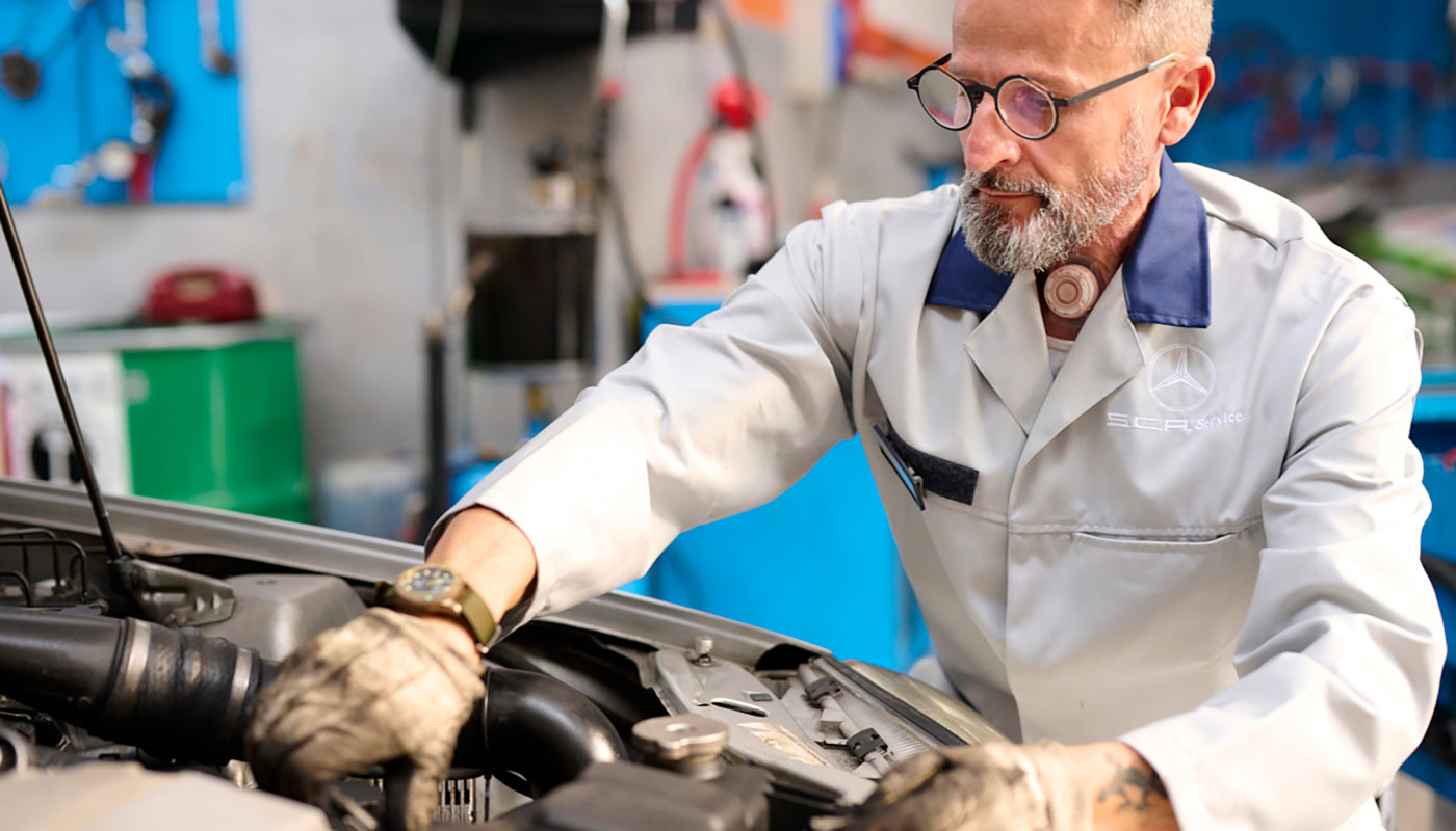 Man fixing car engine living with laryngectomy