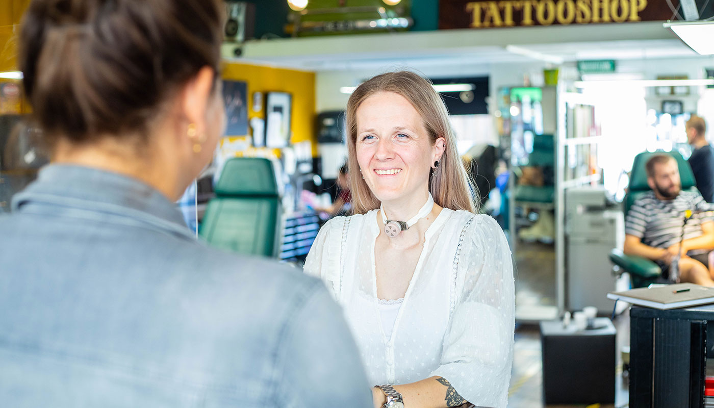 Woman using Freevent DualCare while working in a tattoo shop.